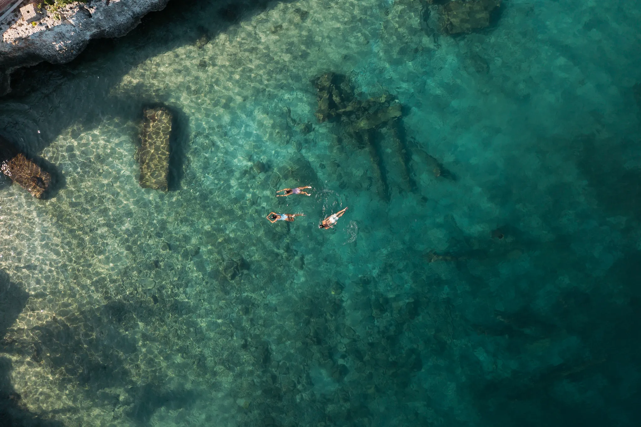 Aerial view of guests swimming in clear turquoise water at Dreams Curaçao Resort.