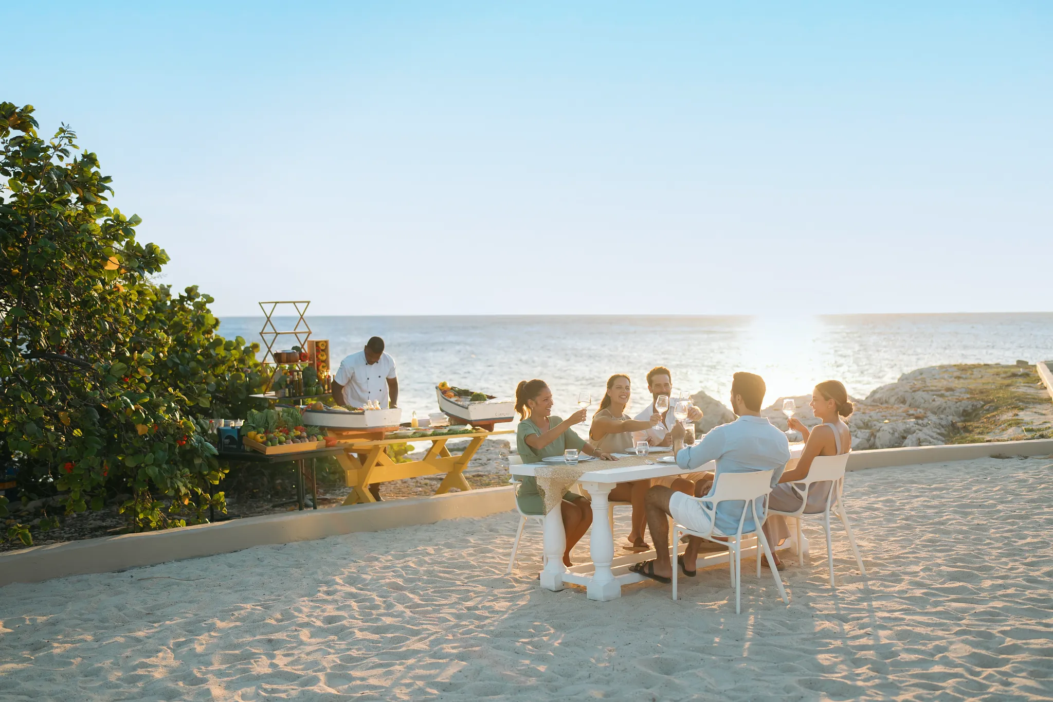 Group enjoying a beachfront dinner at sunset at Dreams Curaçao Resort.