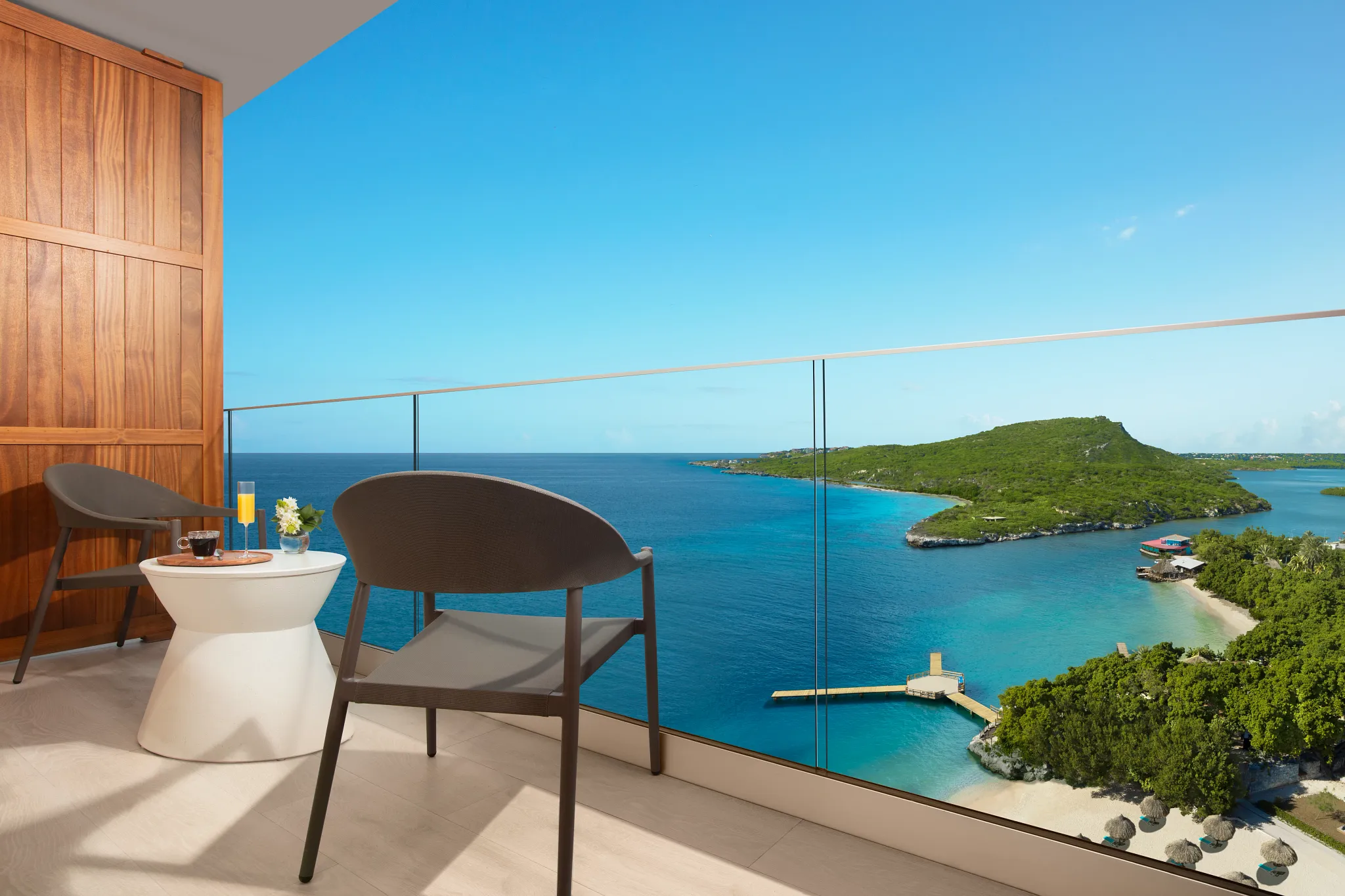 Private balcony with seating and panoramic ocean view at Deluxe Ocean View room in Dreams Curaçao Resort.