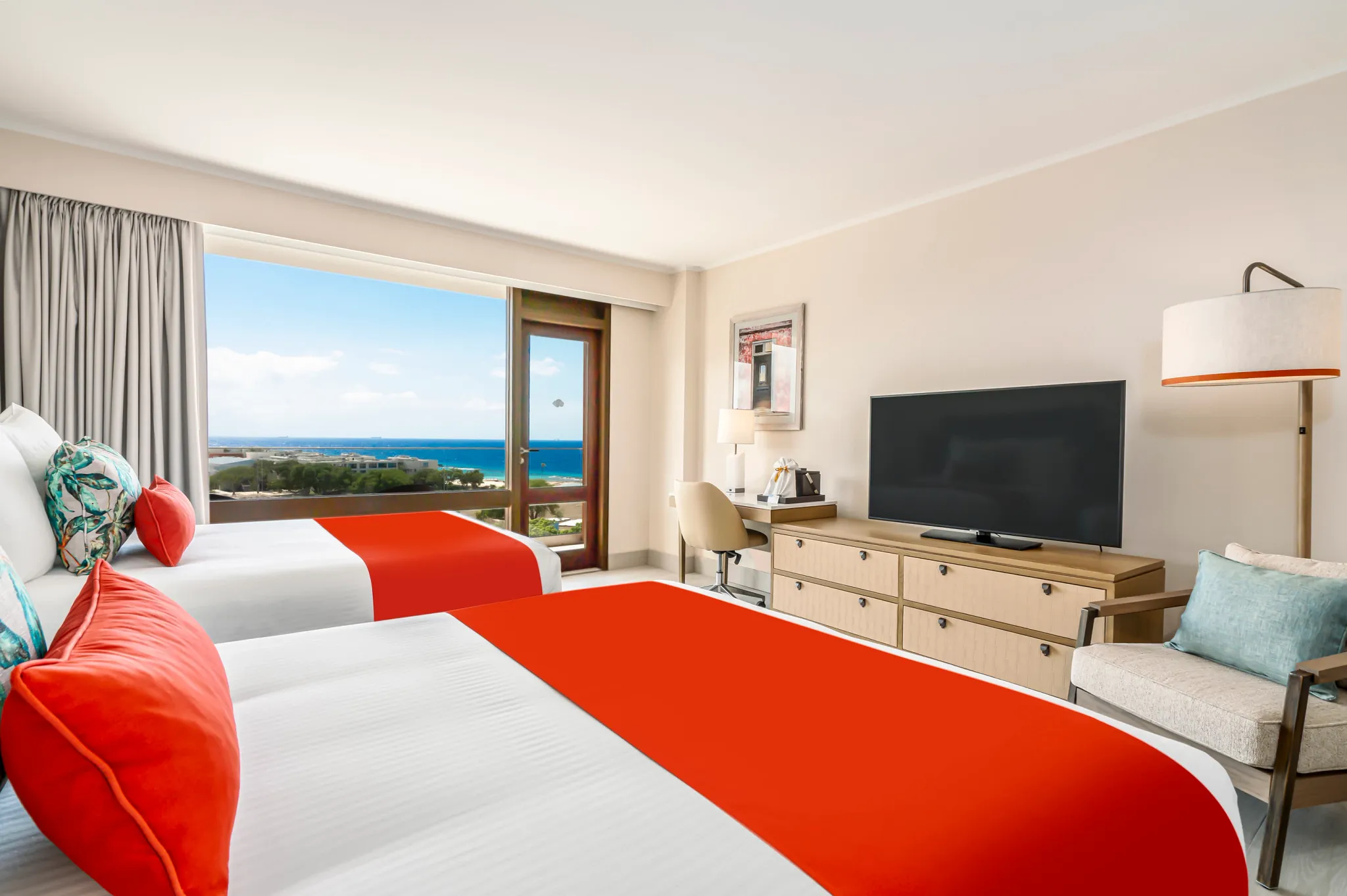 Deluxe Partial Ocean View room with two double beds and balcony at Dreams Curaçao Resort overlooking the Caribbean Sea.