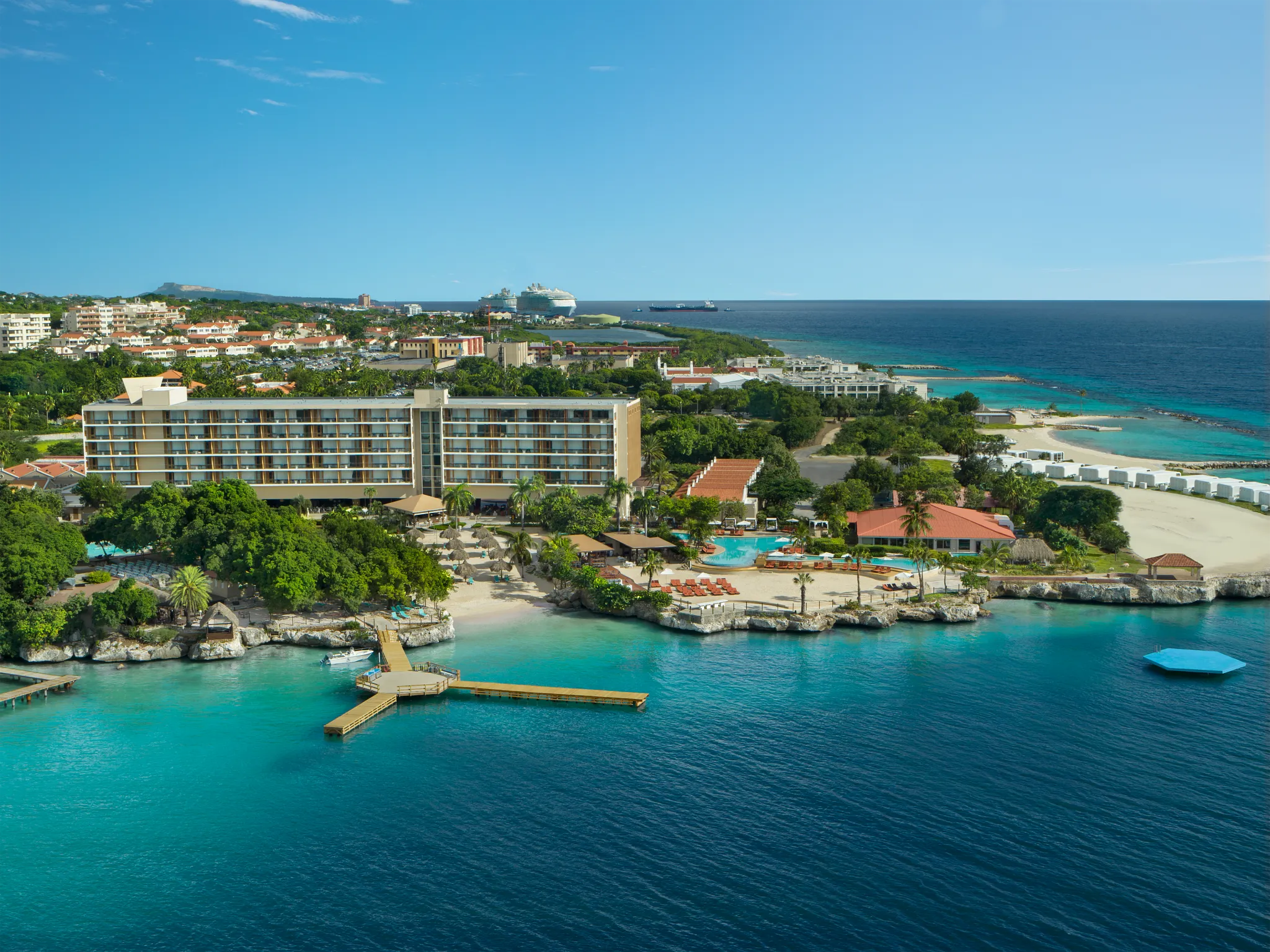 Aerial view of Dreams Curaçao Resort beachfront with pools, cabanas, and Caribbean Sea views.