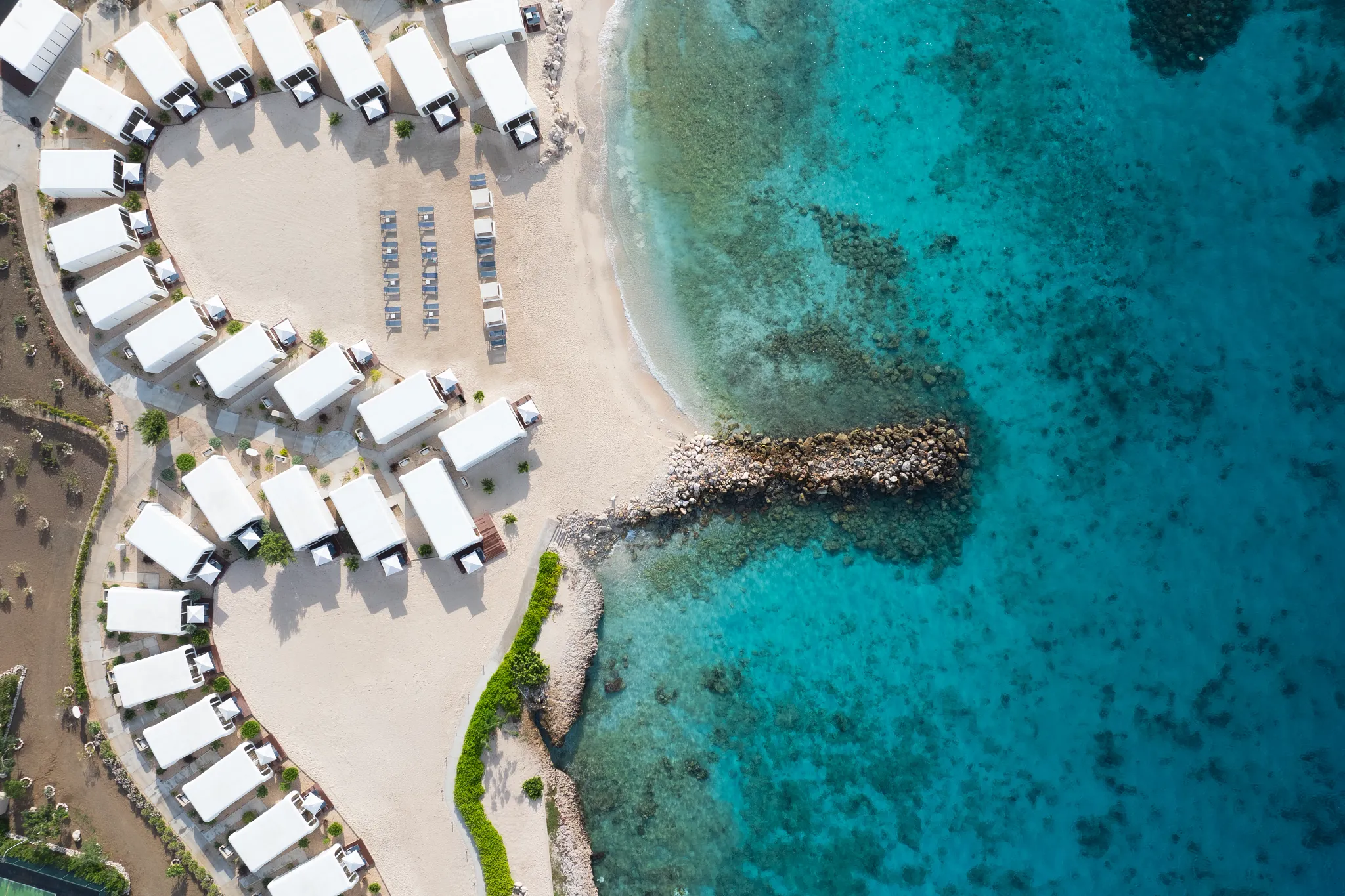 Aerial view of beachfront cabanas and sandy shoreline at Dreams Curaçao Resort.