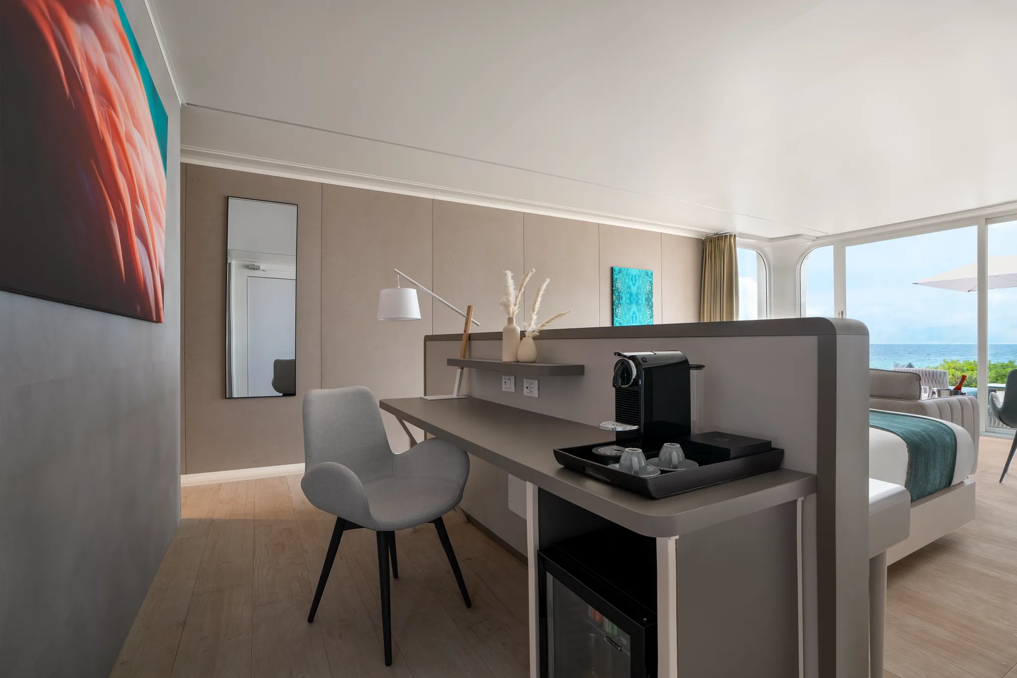 In-room desk with coffee machine and chair inside beachfront bungalow at Dreams Curaçao.