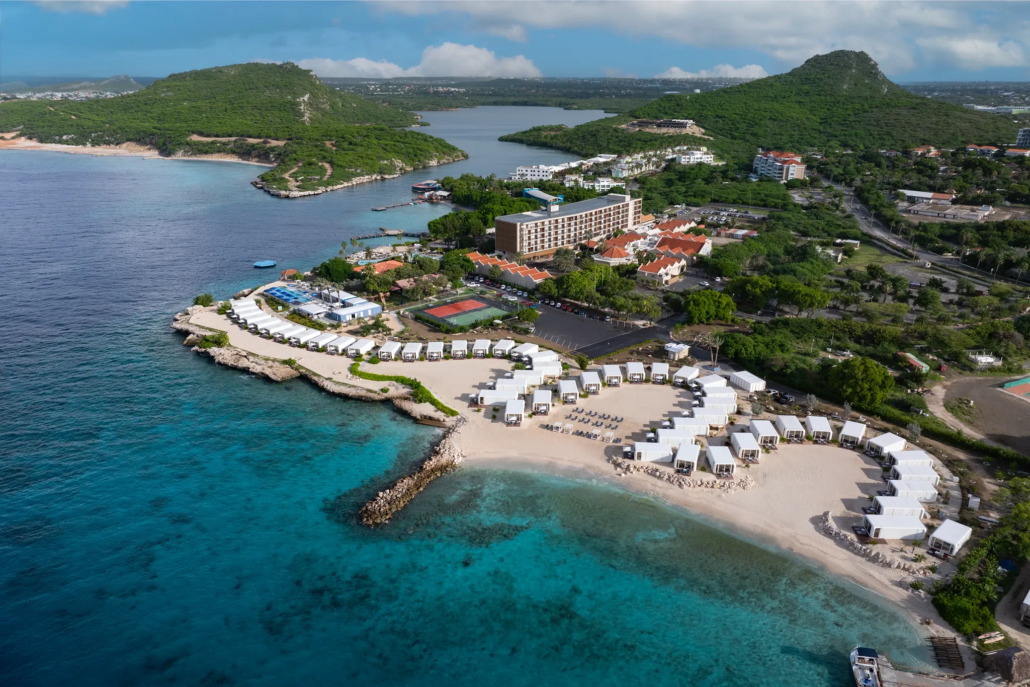 Aerial view of beachfront cabanas and sandy shoreline at Dreams Curaçao Resort.