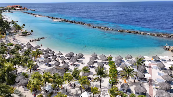 Mambo Beach near Dreams Curaçao Resort, Spa & Casino with lively beachfront, clear waters, and beach club atmosphere
