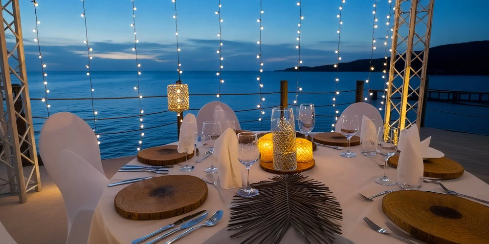 Elegant oceanfront wedding table setup with candles and string lights at Dreams Curaçao