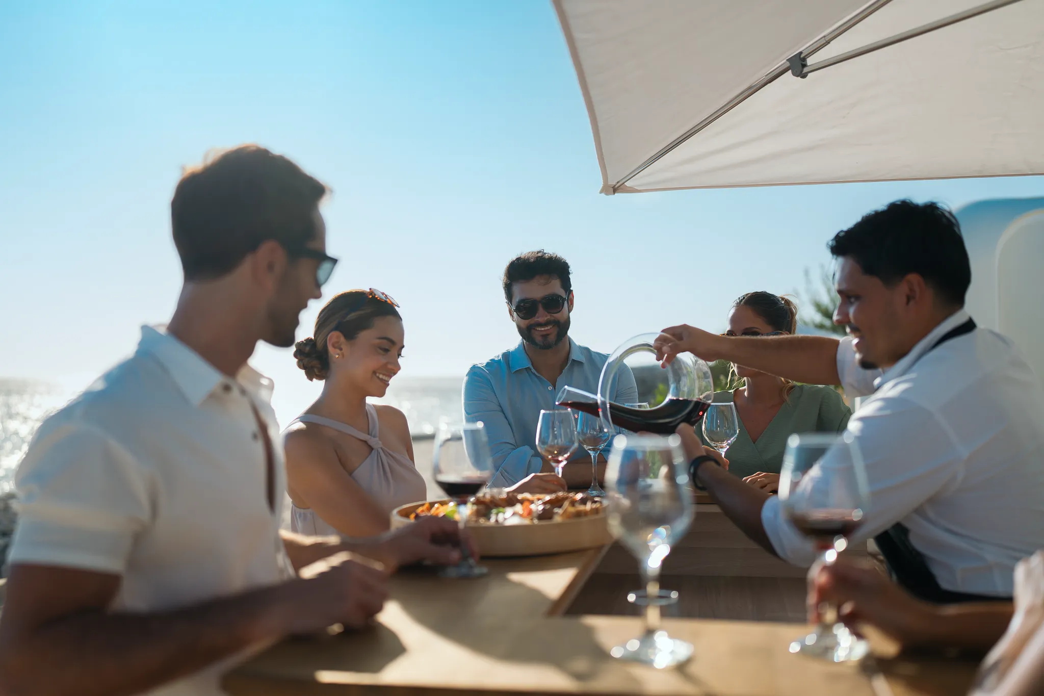 Guests enjoying outdoor dining with wine and sunset views at Dreams Curaçao Resort.