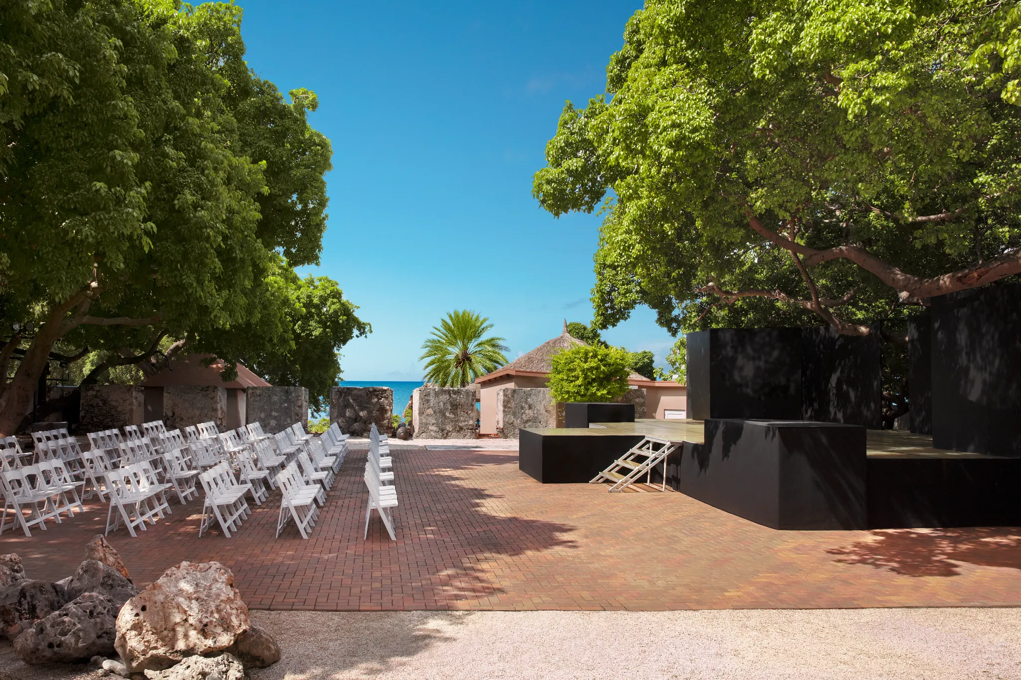 Outdoor oceanfront event space with stage and seating at Dreams Curaçao Resort, ideal for weddings and live entertainment.