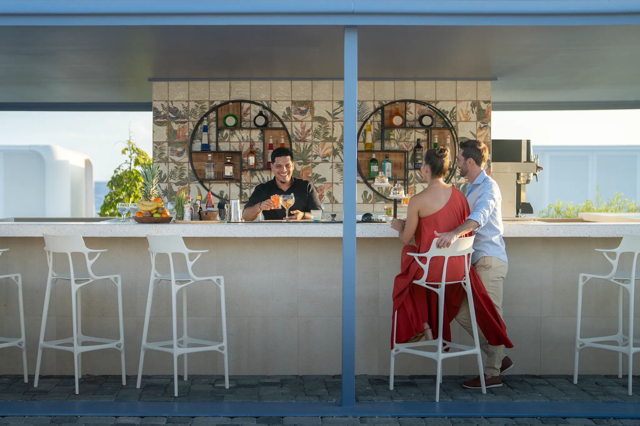 Couple enjoying drinks at an outdoor pool bar at Dreams Curaçao Resort.