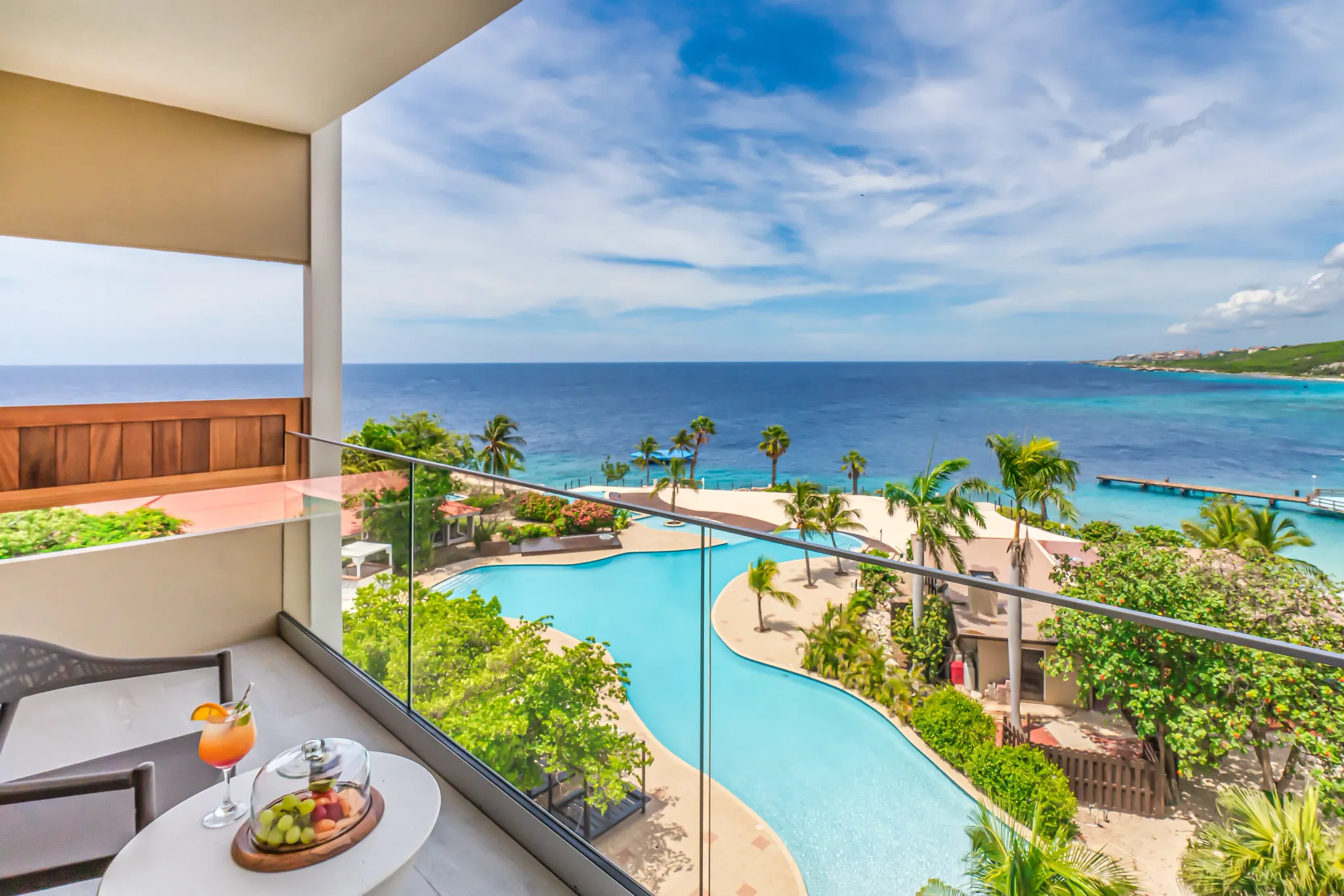Preferred Club Junior Suite Ocean View balcony overlooking pool and Caribbean Sea at Dreams Curaçao Resort.
