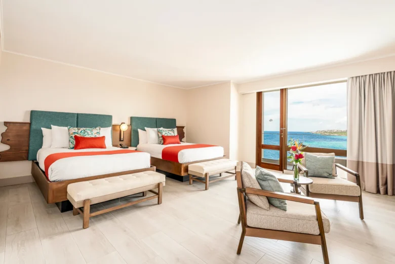 Preferred Club Junior Suite Ocean View with two double beds and sitting area at Dreams Curaçao Resort.