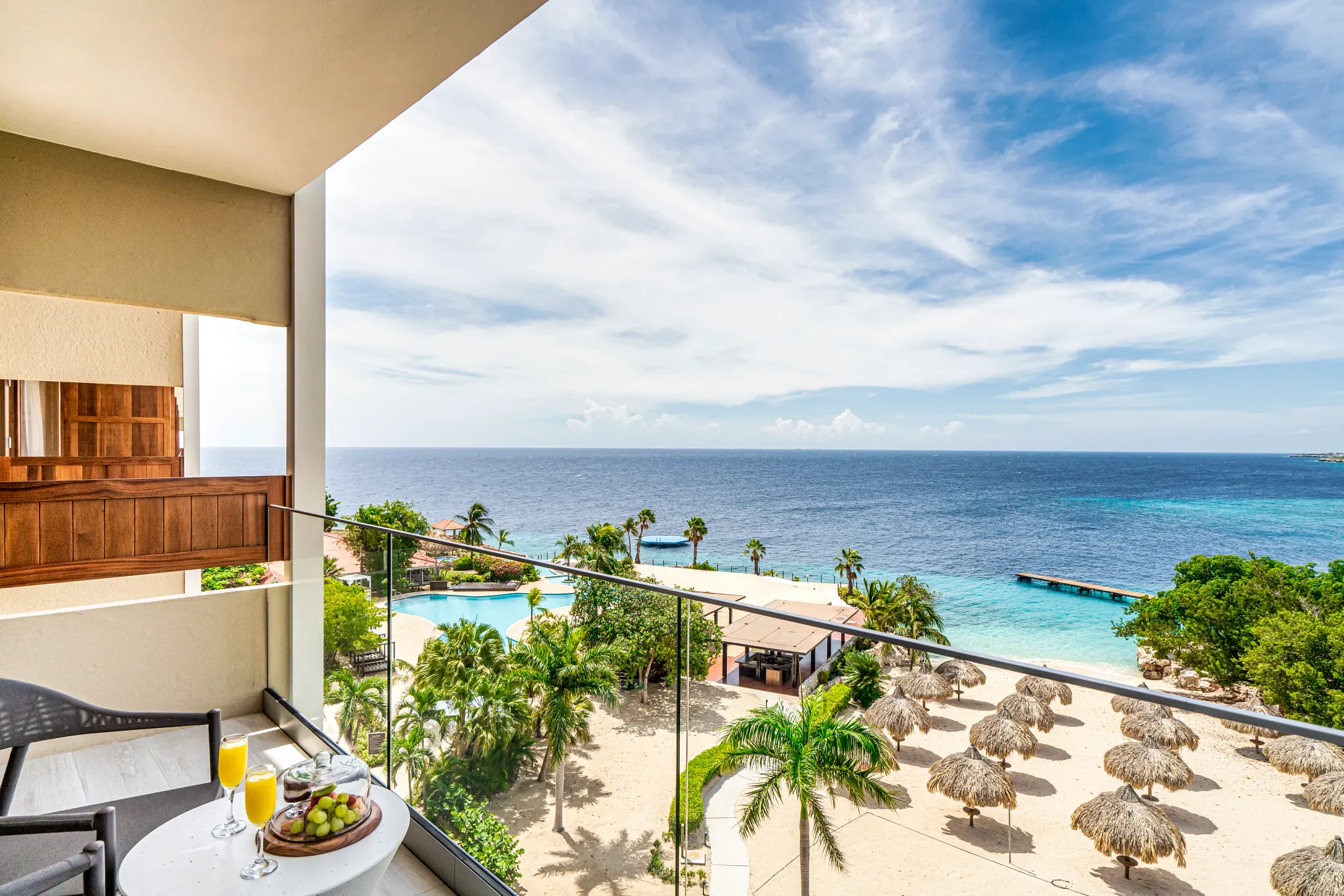 Preferred Club Ocean View balcony with seating overlooking beach and ocean at Dreams Curaçao Resort.