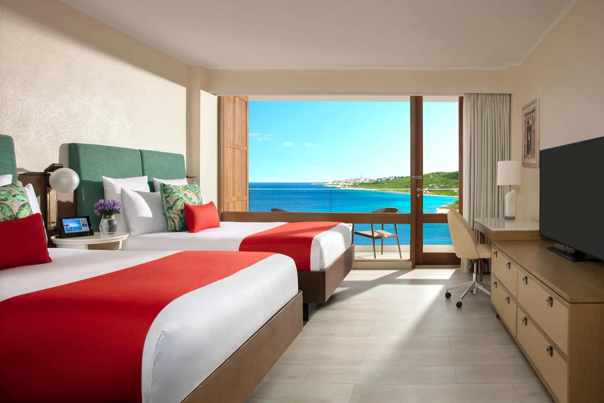 Preferred Club Ocean View room with two double beds and balcony overlooking the ocean at Dreams Curaçao Resort.