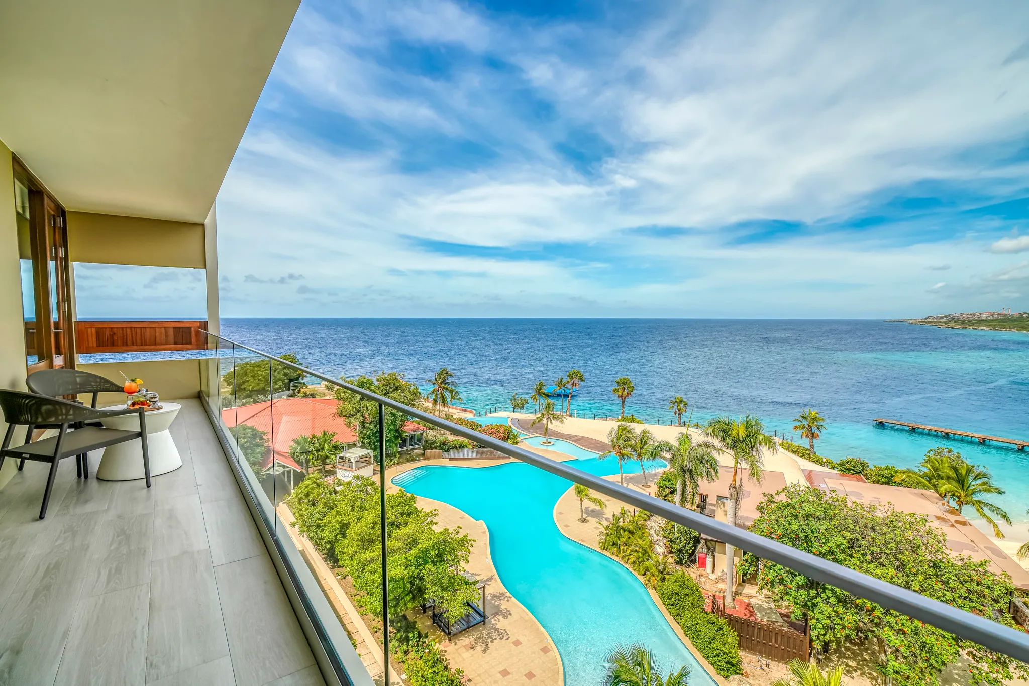 Preferred Club Suite Ocean View balcony overlooking pool and Caribbean Sea at Dreams Curaçao Resort.